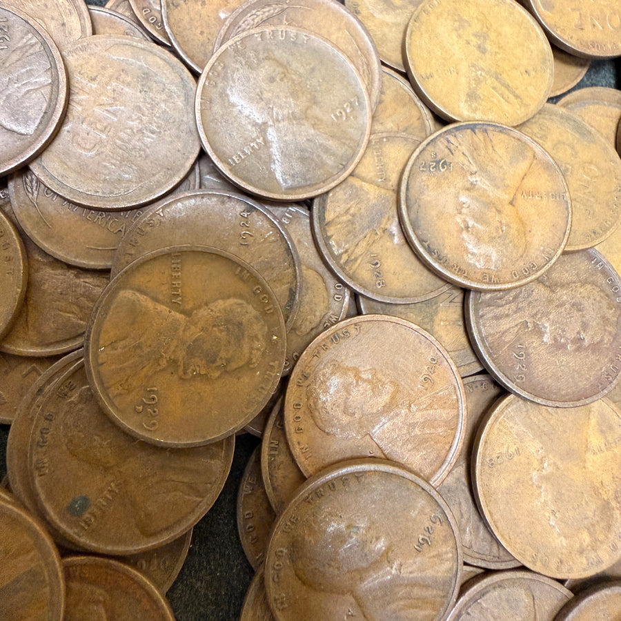 Pile of vintage coins with portraits on a dark surface